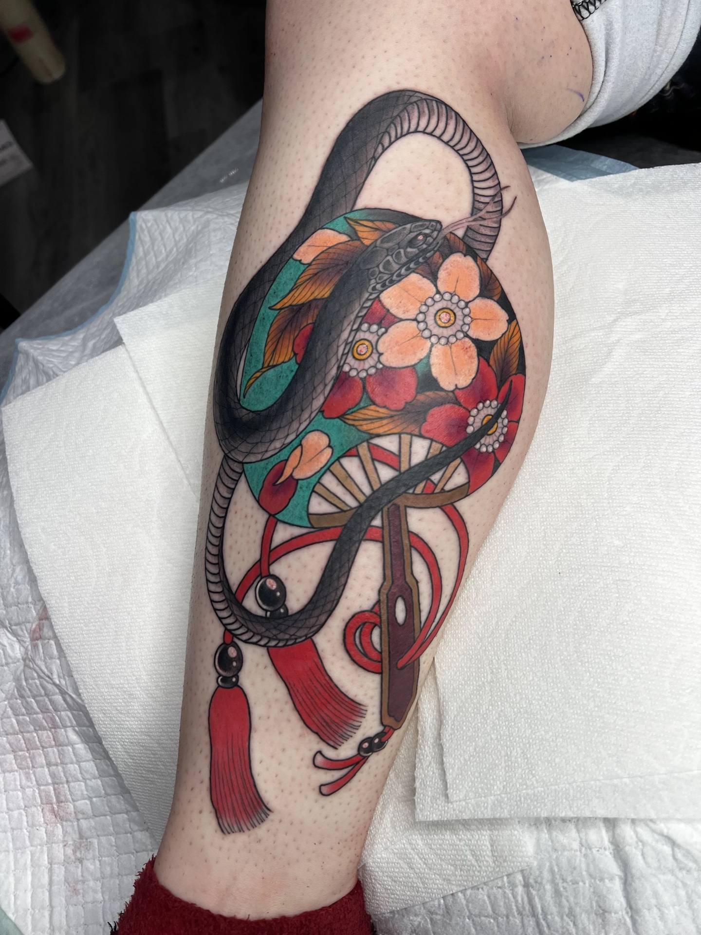 Snake, blossom and fan colour leg tattoo by Levi Taylor