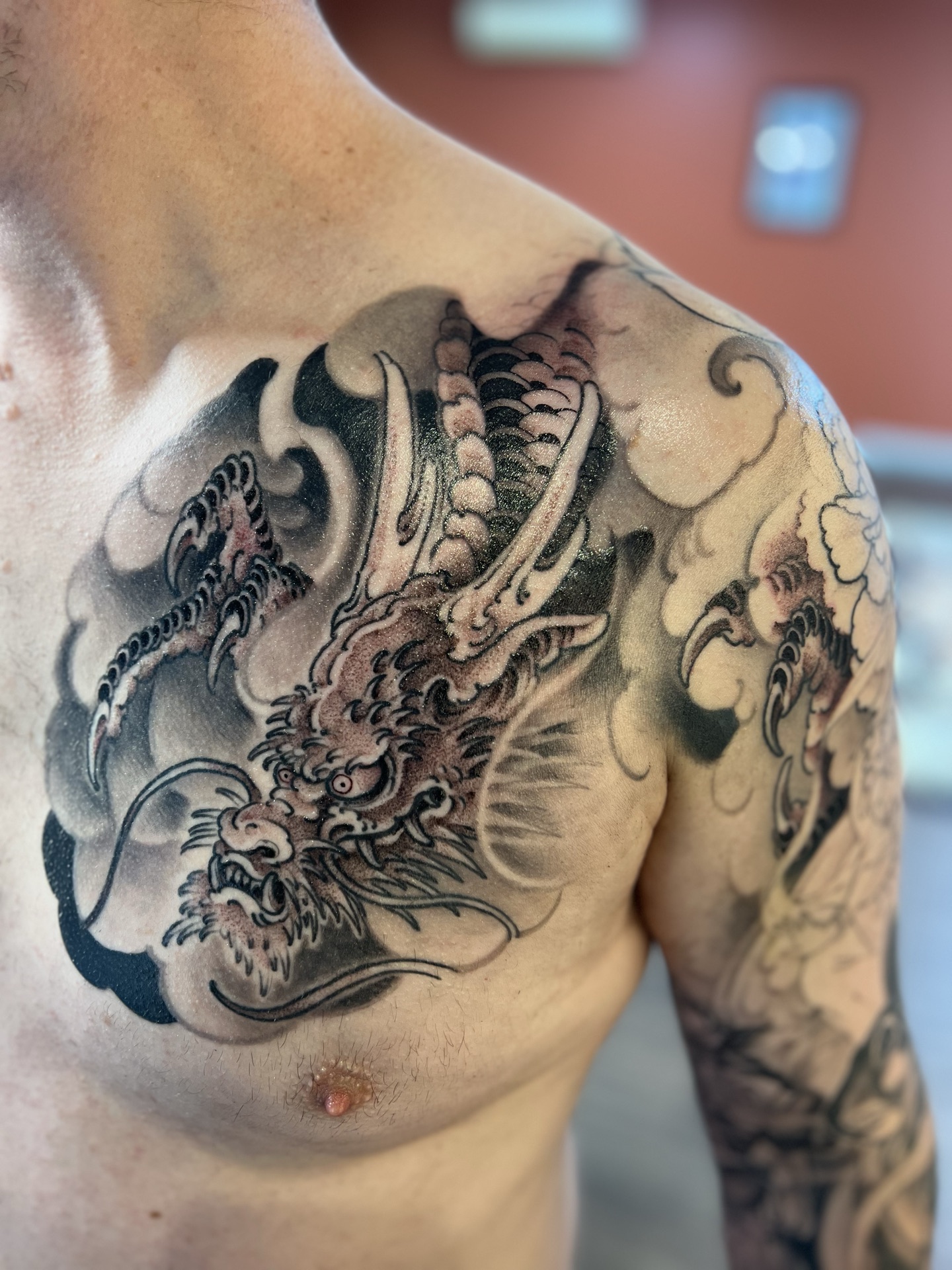 Black and grey dragon chest piece tattoo by Levi Taylor
